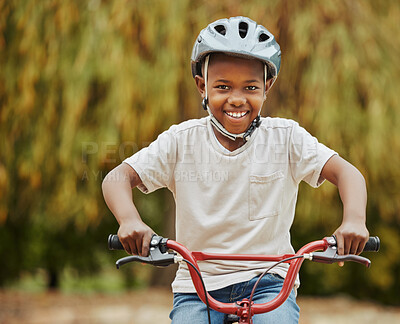 Buy stock photo Shot of a little boy riding his bicycle outside