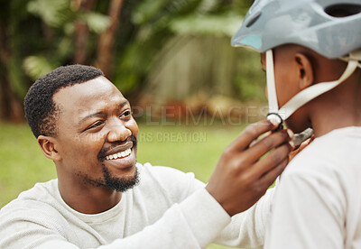 Buy stock photo Shot of a father adjusting his sons helmet outside