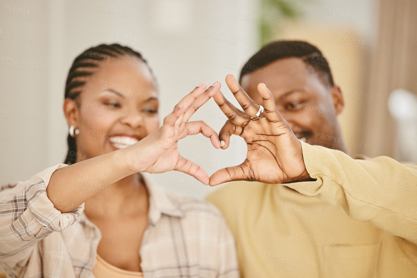 Buy stock photo Heart, hands and couple with love in home for romance, affection and commitment in marriage with smile. African people, emoji and loyalty gesture in living room for caring and trust in relationship