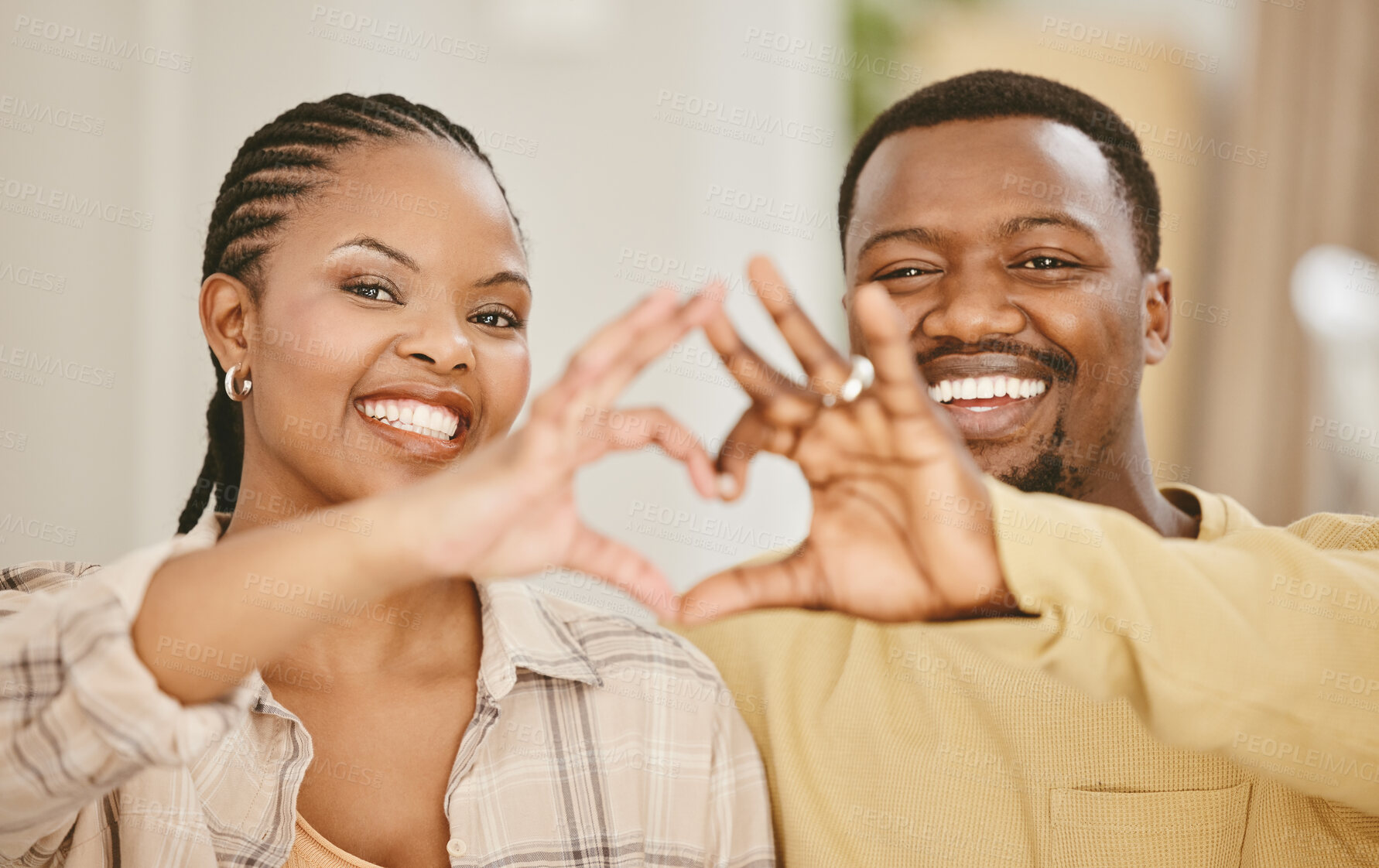 Buy stock photo Heart, hands and couple with portrait in home for romance, affection and commitment in marriage with smile. African people, emoji and love gesture in living room for caring and trust in relationship