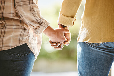 Buy stock photo Cropped shot of an unrecognizable couple holding hands while walking outside