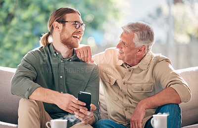 Buy stock photo Shot of a young man using a smartphone with his father on the sofa at home