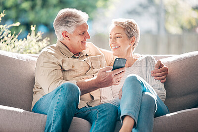Buy stock photo Shot of a happy senior couple using a smartphone on the sofa at home