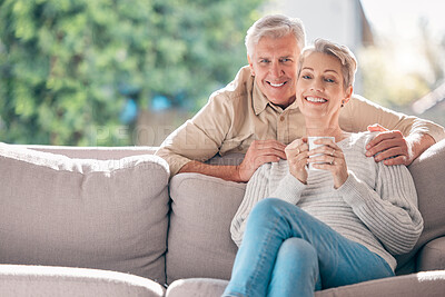 Buy stock photo Portrait of a happy senior couple enjoying a relaxing coffee break on the sofa at home