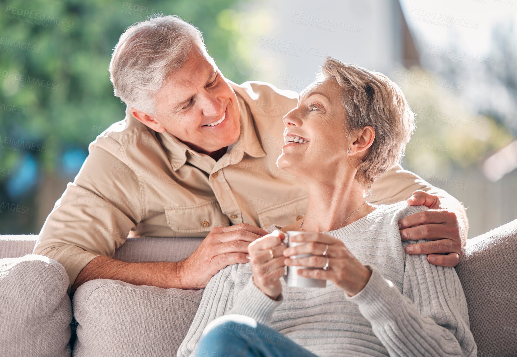 Buy stock photo Shot of a happy senior couple enjoying a relaxing coffee break on the sofa at home