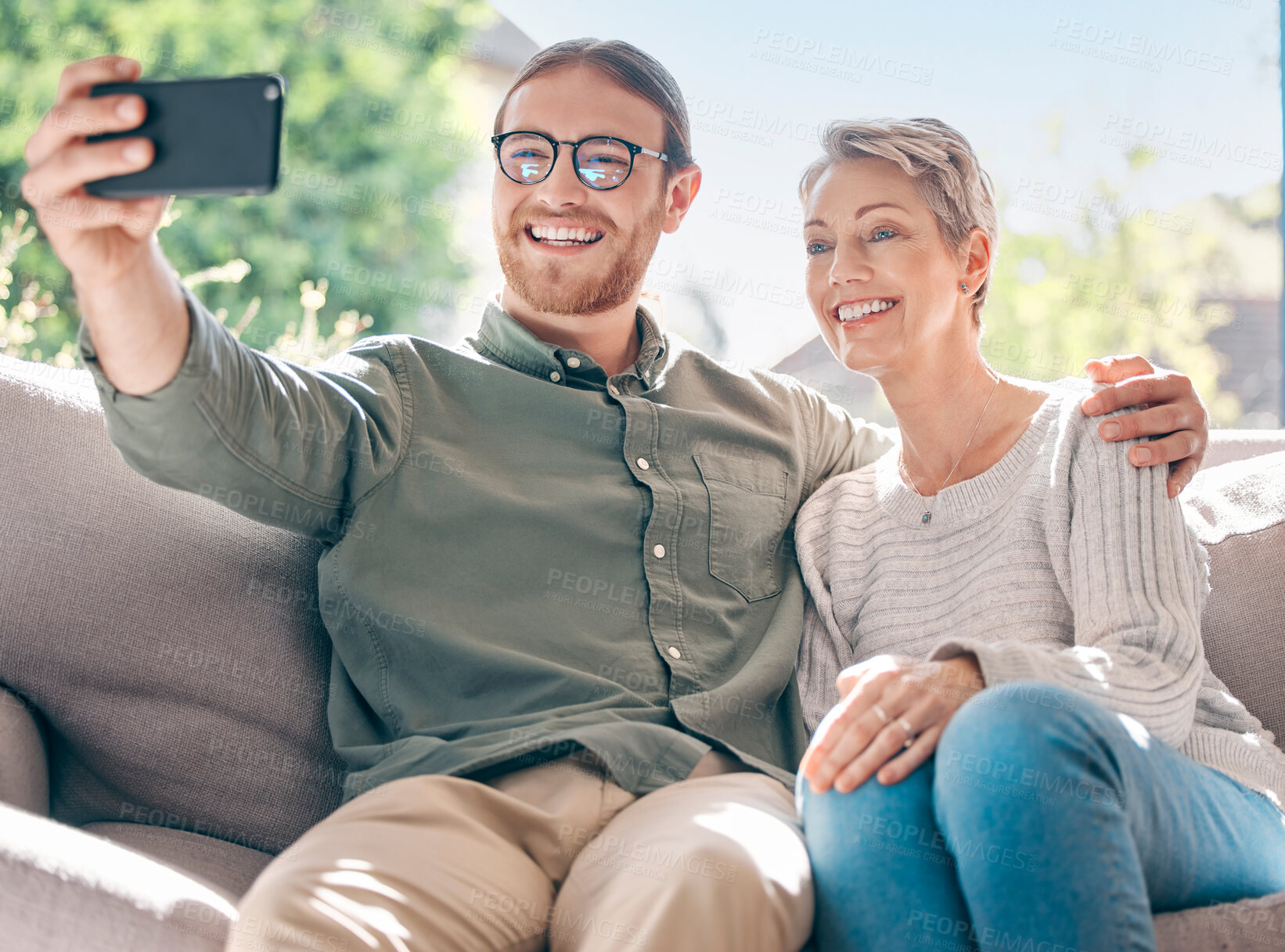 Buy stock photo Happy, mother and son for selfie on sofa for profile picture, social media post and bonding with love in living room. Smile, woman and man with family photography, hug and support for memory at house