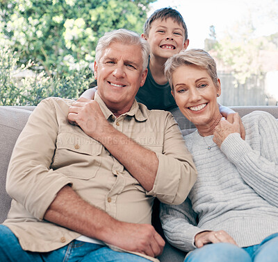 Buy stock photo Portrait of an adorable little boy relaxing with his grandmother and grandfather on the sofa at home