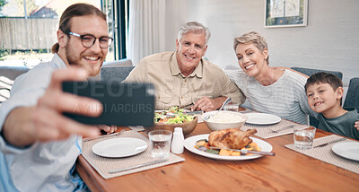 Buy stock photo Shot of a family taking selfies while having a meal together at home