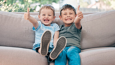 Buy stock photo Shot of two adorable little boys showing thumbs up on the sofa at home