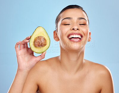 Buy stock photo Studio shot of an attractive young woman posing with an avocado against a blue background