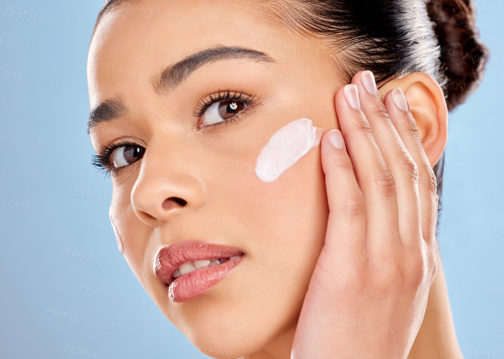 Buy stock photo Portrait, model girl and lotion in studio for skincare, product or cosmetics and dermatology. Woman, moisturiser or cream and face for treatment with luxury, glow and benefits by blue background