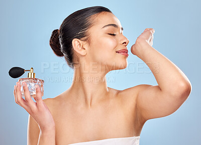 Buy stock photo Perfume, fragrance and woman with wrist smell for clean scent and beauty salon aesthetic in studio. Wellness, model girl and parfum bottle with spray skin for self care and fresh by blue background