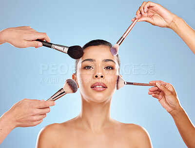 Buy stock photo Studio portrait of an attractive young woman having makeup applied to her face against a blue background
