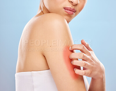 Buy stock photo Studio shot of an unrecognisable woman scratching her arm against a blue background