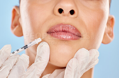 Buy stock photo Studio portrait of an unrecognisable woman receiving a botox injection against a blue background
