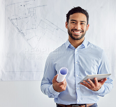 Buy stock photo Shot of a young male architect using a digital tablet at work