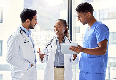 Buy stock photo Shot of a group of doctors using a digital tablet at work