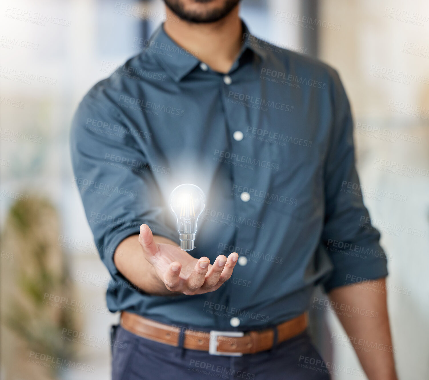 Buy stock photo Shot of an unrecognisable businessman holding a lightbulb in a modern office