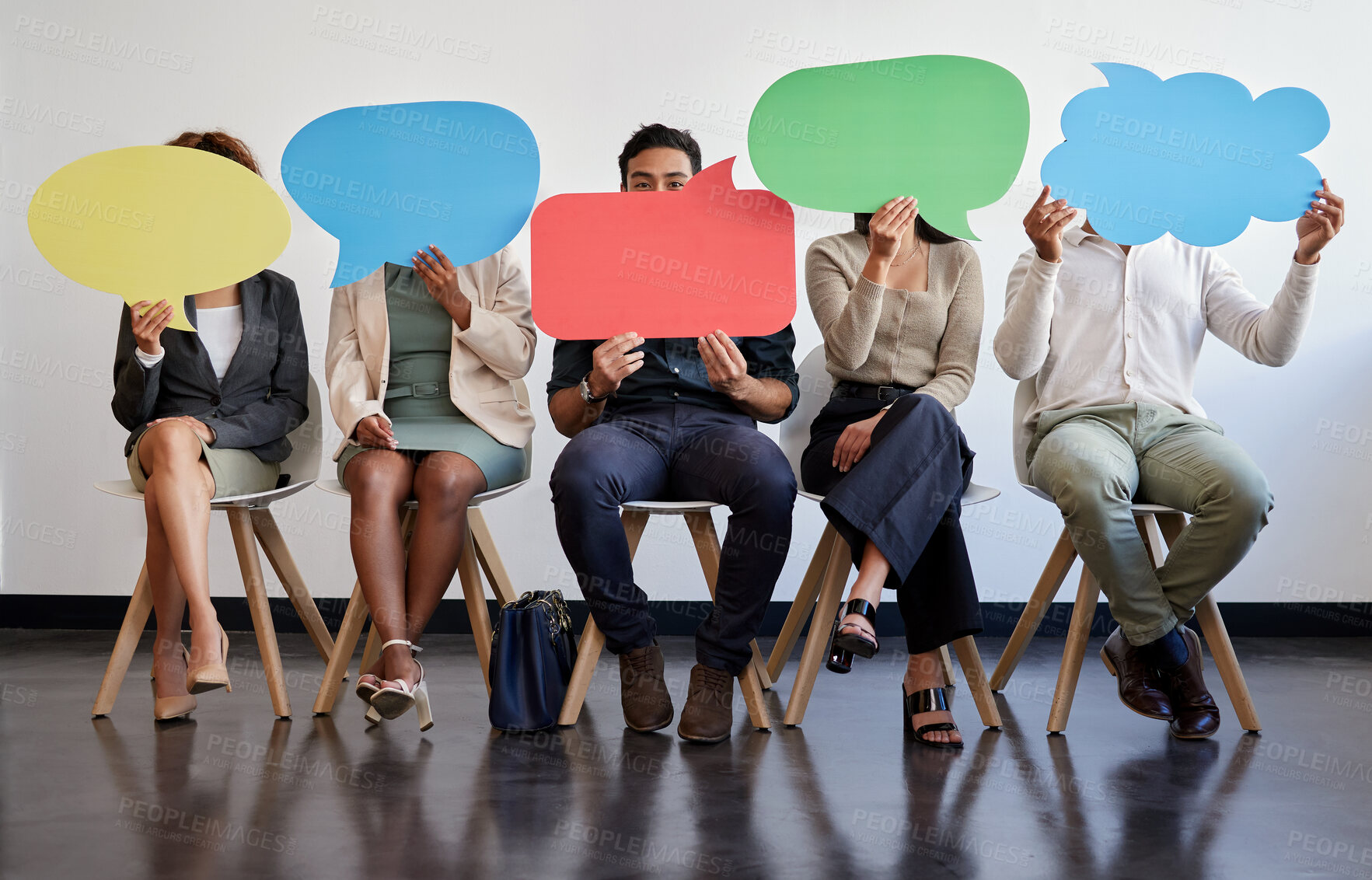 Buy stock photo Shot of a group of young businesspeople holding speech bubbles while waiting in line