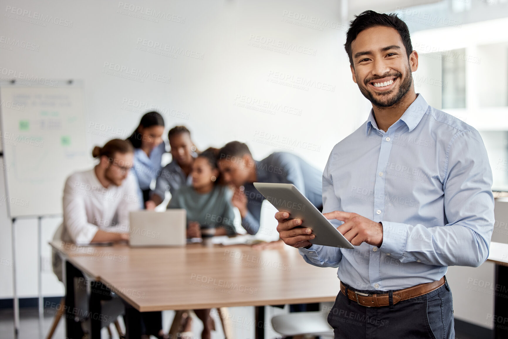 Buy stock photo Shot of a businessman holding a digital tablet while standing in the boardroom