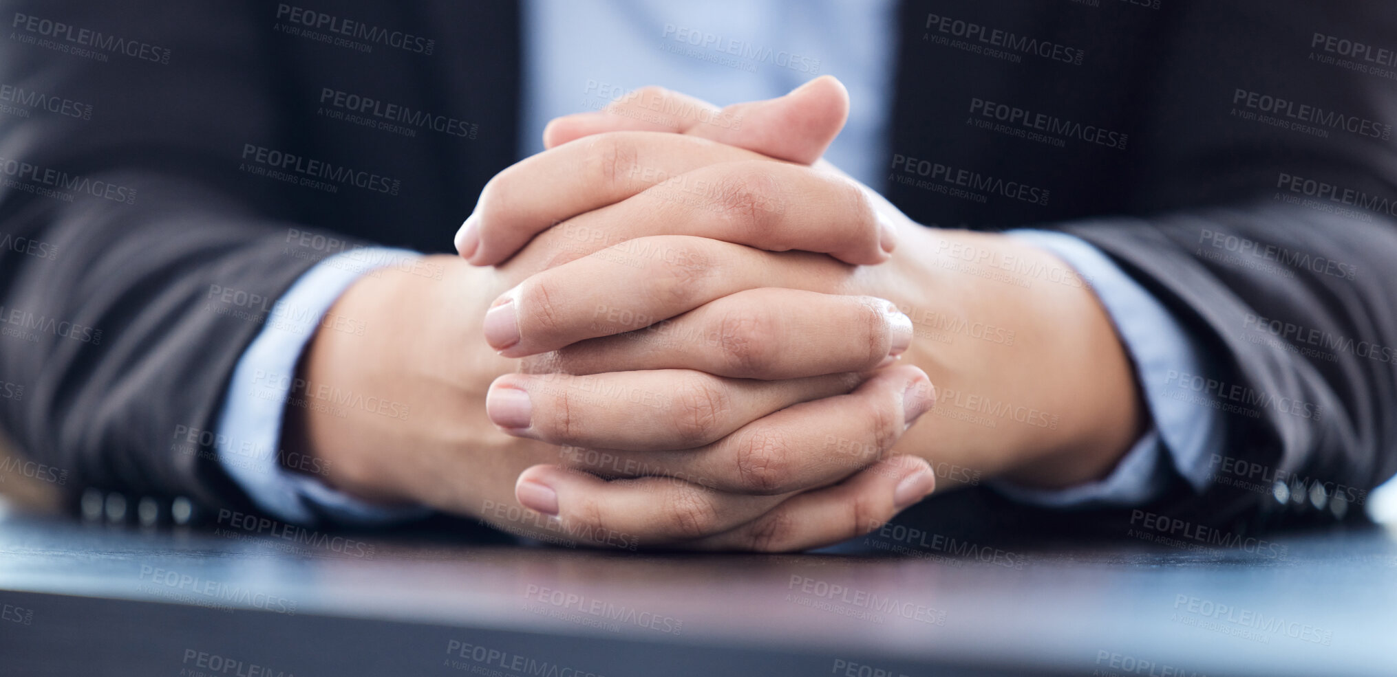 Buy stock photo Cropped shot of an unrecognisable businesswoman sitting alone in his office with his hands clasped