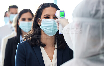 Buy stock photo Shot of a group of businesspeople standing in a line to get their temperature's read