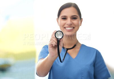 Buy stock photo Shot of a young female doctor holding up a stethoscope at a clinic