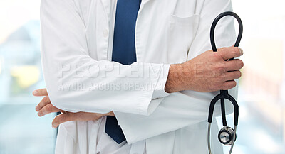 Buy stock photo Shot of an unrecognizable doctor standing with their arms crossed while holding a stethoscope at a clinic