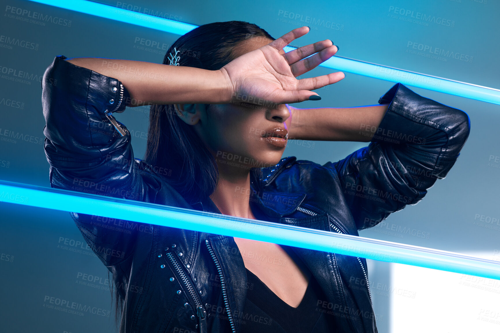 Buy stock photo Conceptual shot of a stylish young woman posing in studio against a blue background