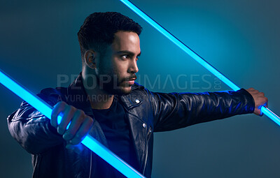 Buy stock photo Conceptual shot of a stylish young man posing in studio against a blue background