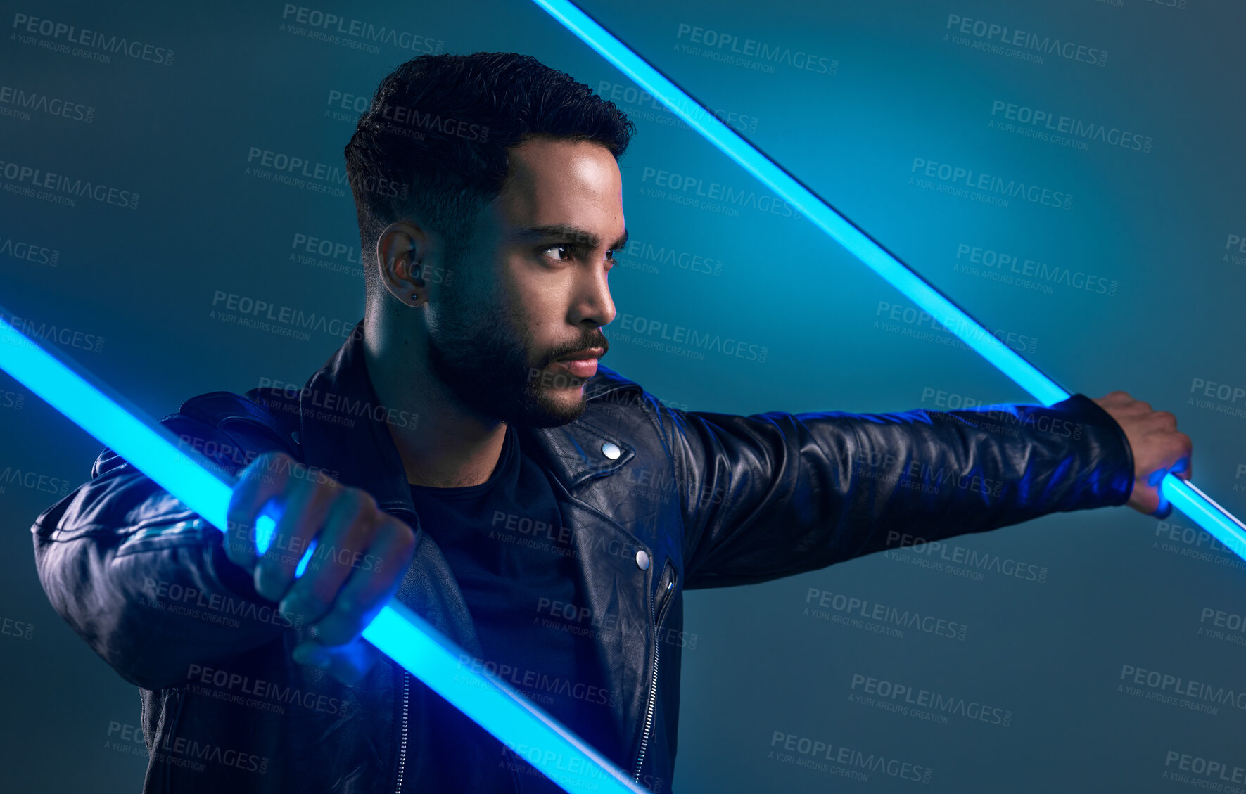 Buy stock photo Conceptual shot of a stylish young man posing in studio against a blue background