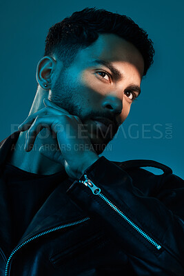 Buy stock photo Conceptual shot of a stylish young man posing in studio against a blue background