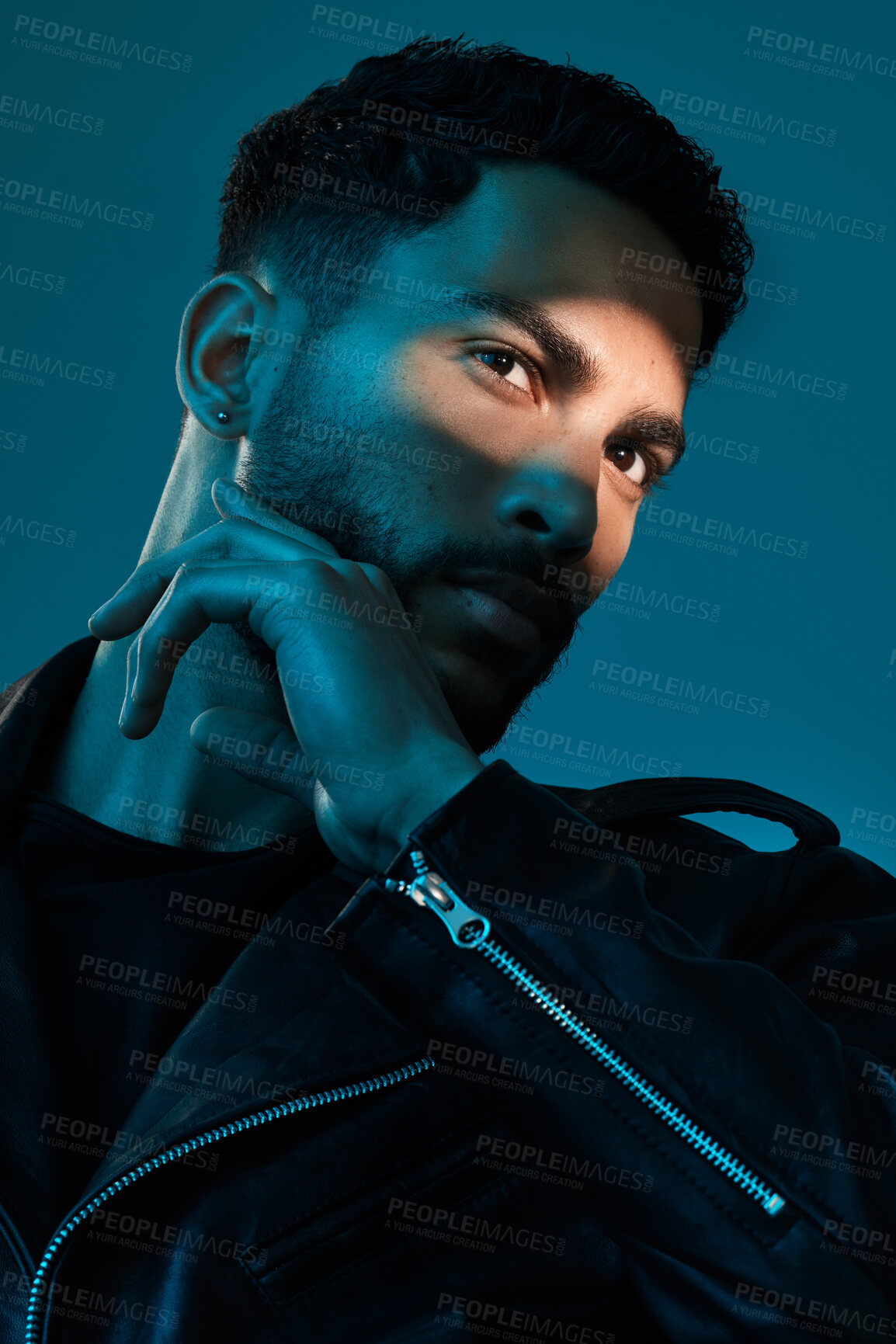 Buy stock photo Conceptual shot of a stylish young man posing in studio against a blue background