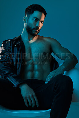 Buy stock photo Conceptual shot of a stylish young man posing in studio against a blue background