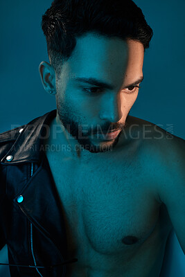 Buy stock photo Conceptual shot of a stylish young man posing in studio against a blue background