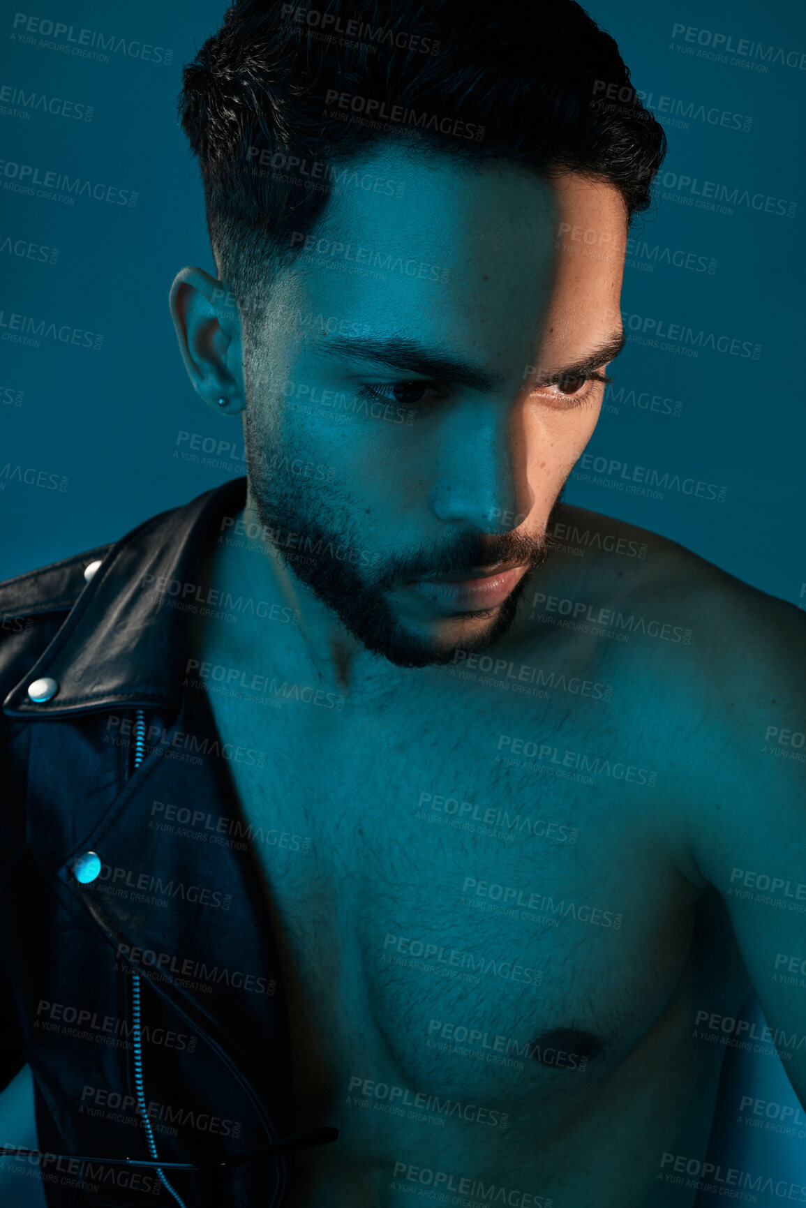 Buy stock photo Conceptual shot of a stylish young man posing in studio against a blue background