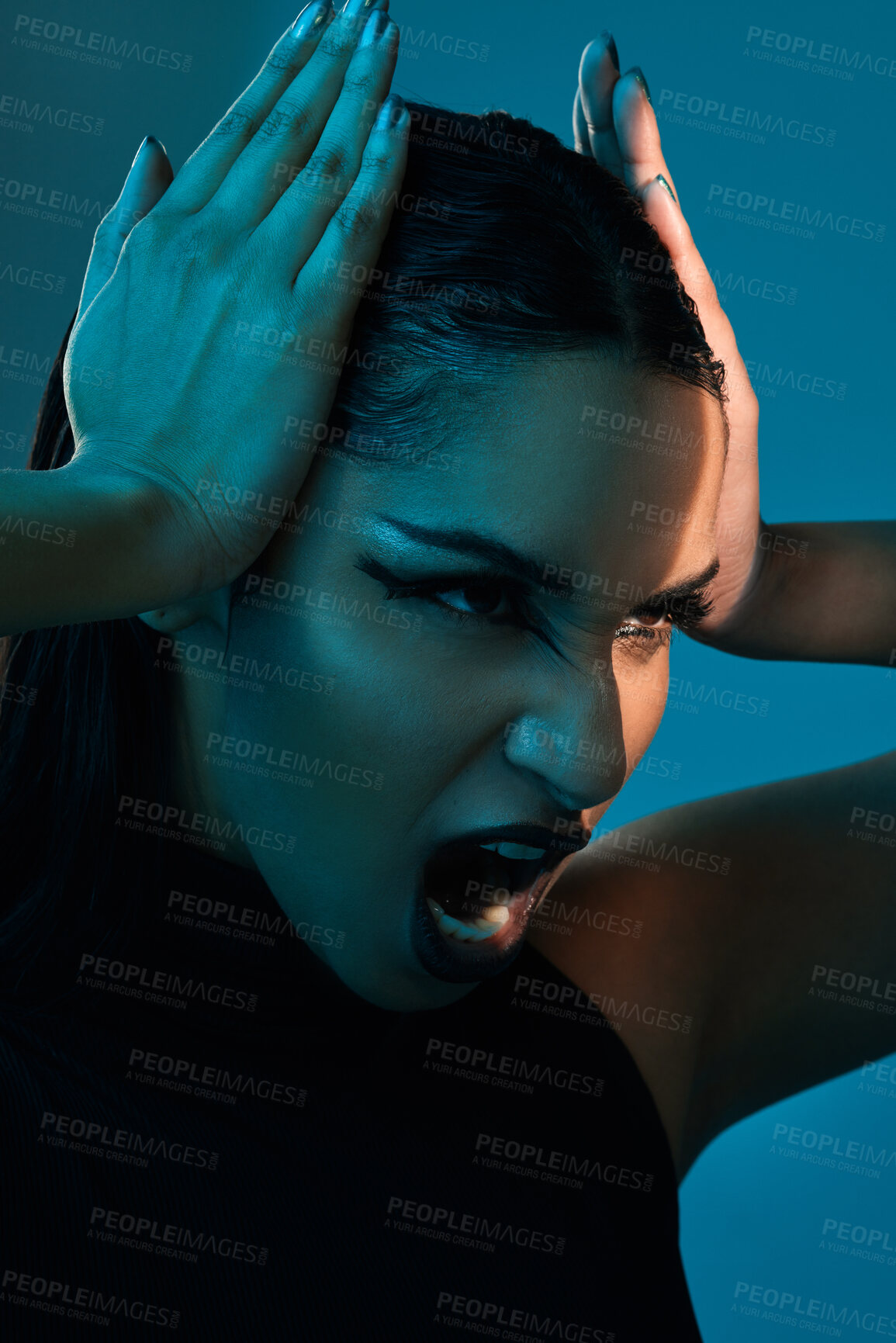 Buy stock photo Conceptual shot of a stylish young woman posing in studio against a blue background