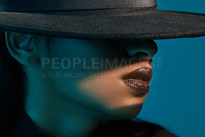 Buy stock photo Conceptual shot of a stylish young woman posing in studio against a blue background