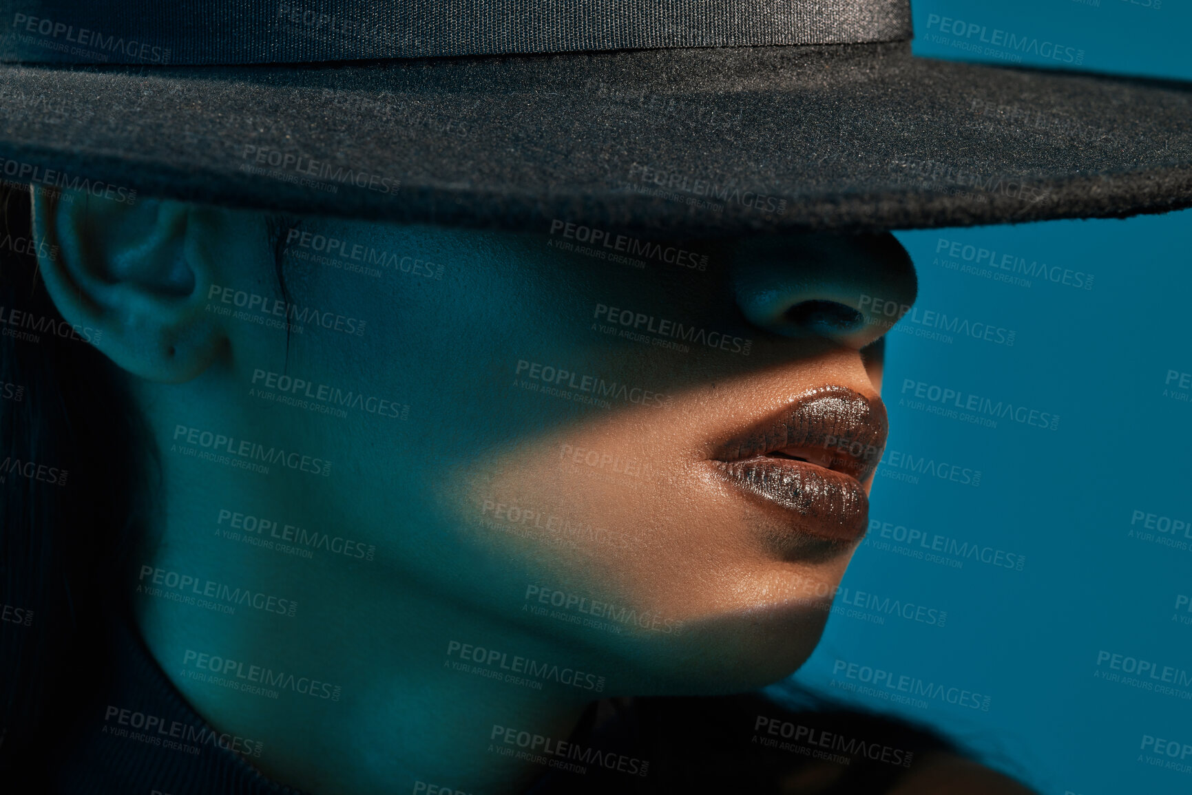 Buy stock photo Conceptual shot of a stylish young woman posing in studio against a blue background