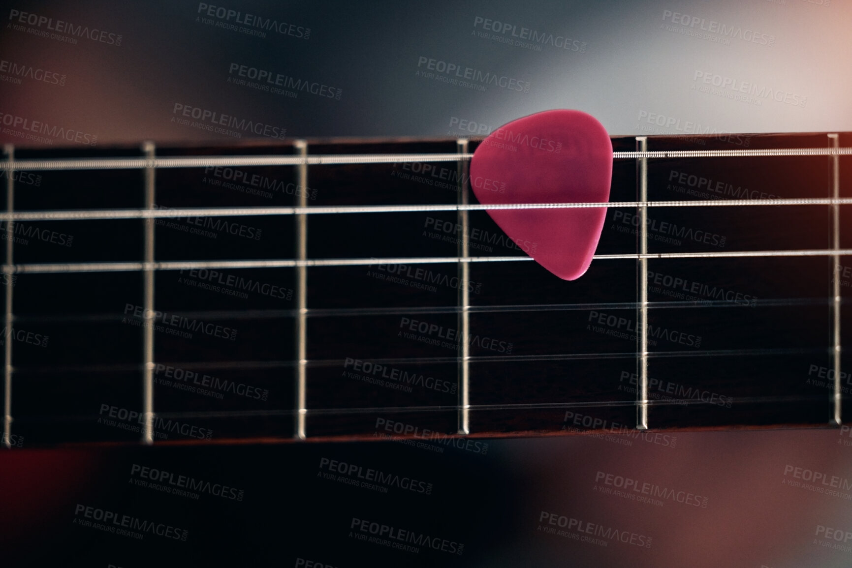 Buy stock photo Closeup shot of a guitar pick in between guitar sticks