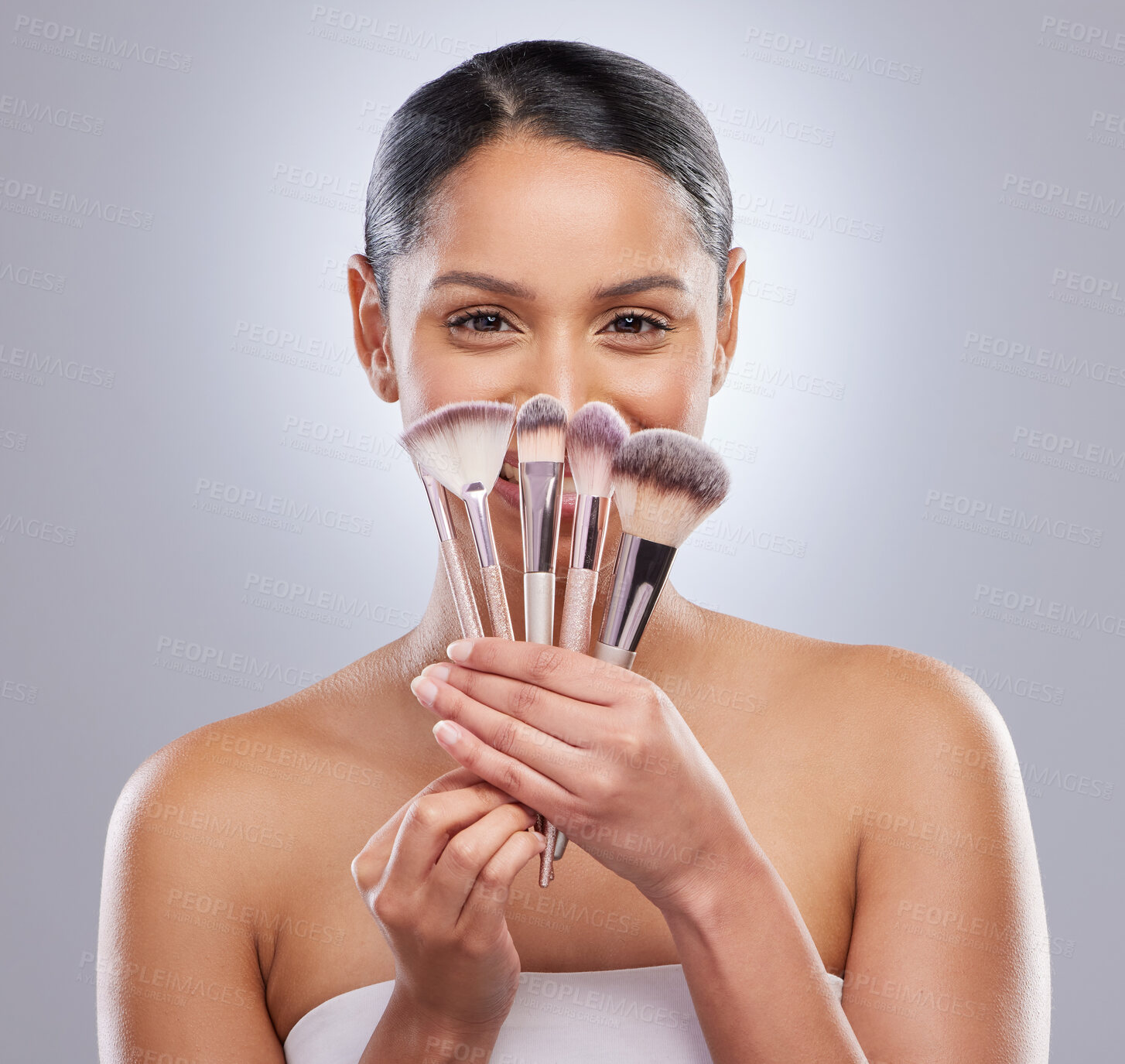 Buy stock photo Cosmetic brushes, woman and portrait in studio with smile for beauty, happy and morning routine on gray background. Female latino, fashion and makeup artist with tools for blush or eyeshadow