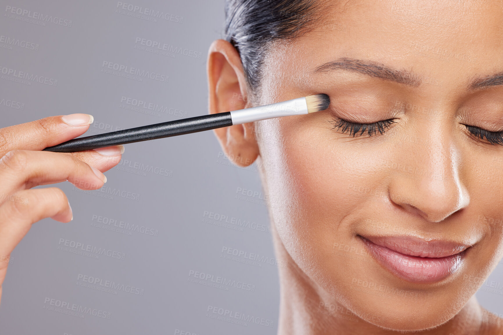 Buy stock photo Woman, makeup and smile with brush on face, beauty and cosmetic tools and eyes closed in studio background. Model, person and happy for transformation or skincare,  glow and health for self care