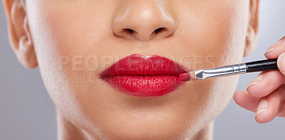 Buy stock photo Cropped shot of an unrecognisable woman posing in the studio while a makeup artist applies lipstick
