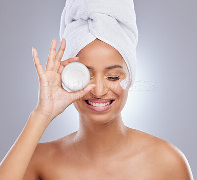 Buy stock photo Shot of an attractive young woman feeling playful while posing with a container of moisturiser in the studio