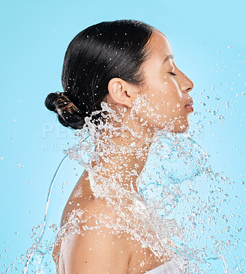 Buy stock photo Beauty, water and face of woman on blue background for wellness, healthy skin and cleaning in studio. Skincare, shower and female person profile with splash for facial grooming, washing and body care