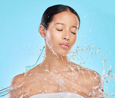 Buy stock photo Skincare, water and face of woman on blue background for wellness, healthy skin and cleaning in studio. Bathroom, shower and female person with liquid splash for facial grooming, washing and beauty