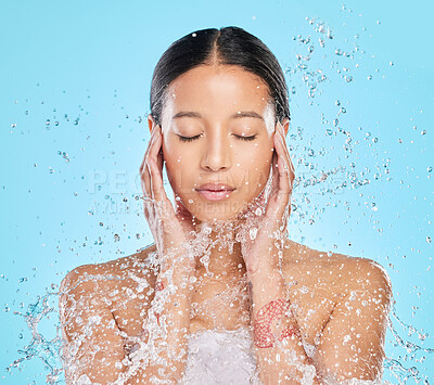 Buy stock photo Skincare, water splash and face of woman in studio for wellness, healthy skin and cleaning. Bathroom, shower and female person with liquid for facial grooming, washing and beauty on blue background