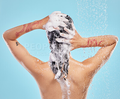 Buy stock photo Shot of a beautiful young woman enjoying a shower against a blue background