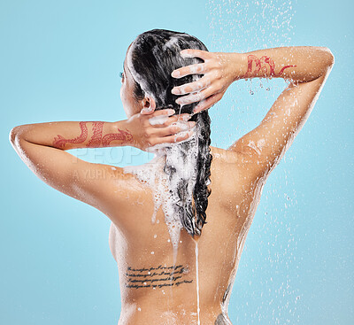 Buy stock photo Shot of a beautiful young woman enjoying a shower against a blue background