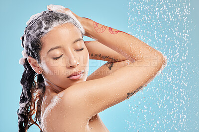 Buy stock photo Shot of a beautiful young woman enjoying a shower against a blue background